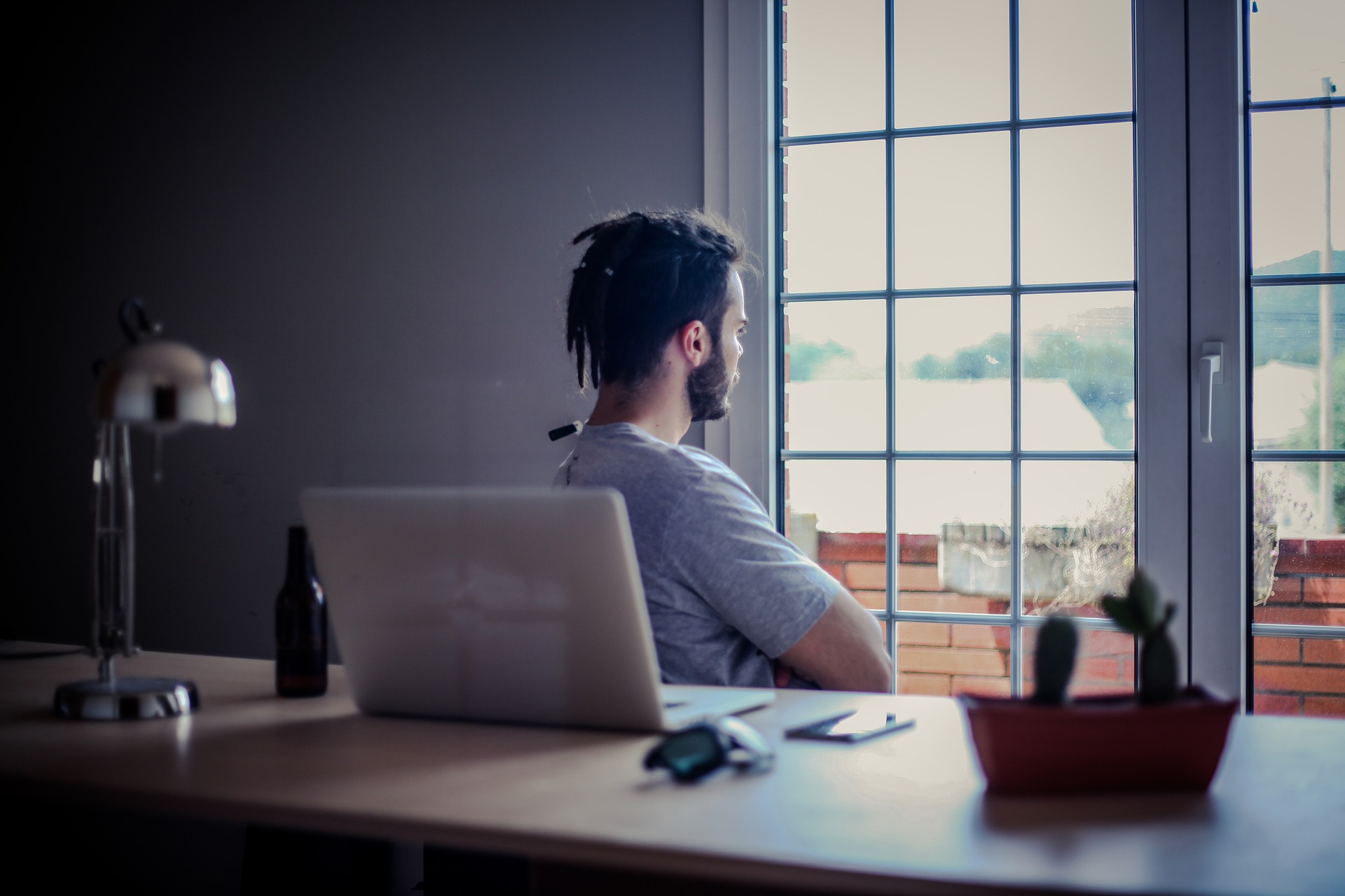 man-at-desk-staring-outside-window